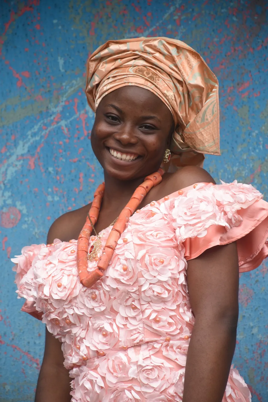Girl in a pink dress and gele smiling